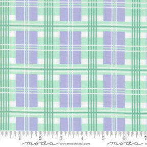 The image is a fabric with a repeating pattern of purple and green plaid squares. The pattern is composed of diagonal lines connecting the squares, creating a visually appealing and textured design. The fabric appears to be made of a soft, plush material, suitable for clothing or home decor items.