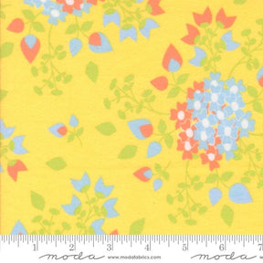 The image is a close-up of a fabric with a floral pattern in shades of yellow, blue, and orange.