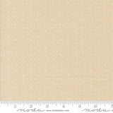 The image is a fabric sample with a light beige pattern, featuring small white dots or stars. The fabric is displayed on a ruler for scale, indicating its size.