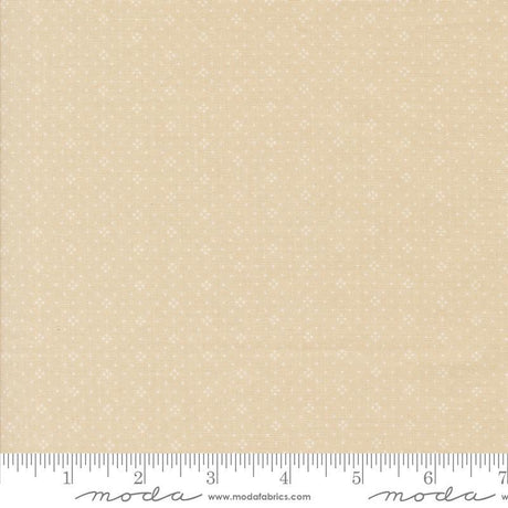 The image is a fabric sample with a light beige pattern, featuring small white dots or stars. The fabric is displayed on a ruler for scale, indicating its size.