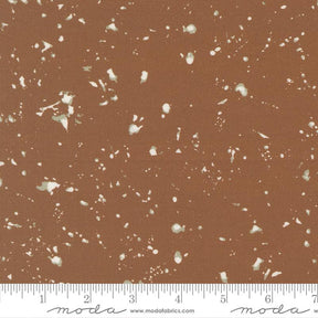 The image is a brown fabric with white speckles or dots scattered across it.