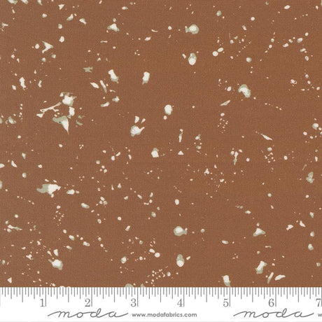 The image is a brown fabric with white speckles or dots scattered across it.