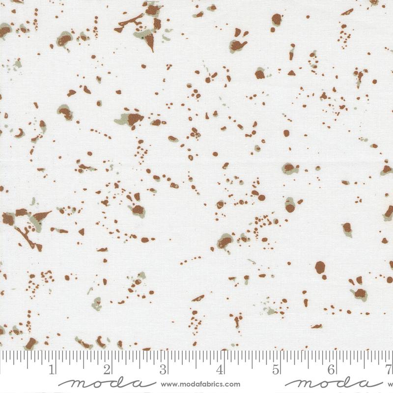 The image is a fabric with a white background and brown splatter-like patterns.