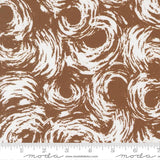 The image is a close-up of a brown and white patterned fabric, featuring a repeating swirl design.