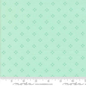 The image is a fabric with a repeating pattern of small green diamond shapes.