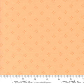 The image is a fabric with a repeating pattern of small orange dots or stars on a light orange background.