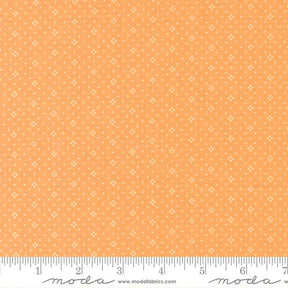 The image is a fabric with a repeating pattern of small white dots or stars on an orange background.