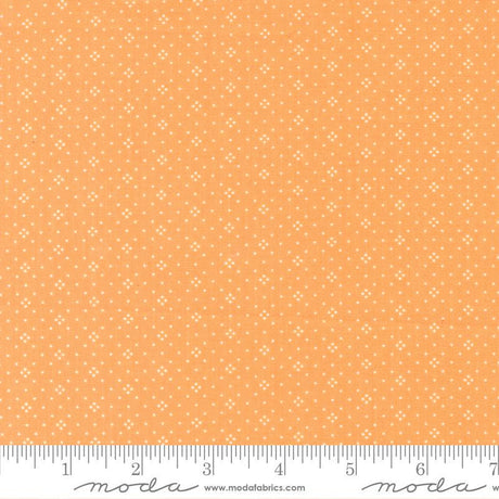 The image is a fabric with a repeating pattern of small white dots or stars on an orange background.
