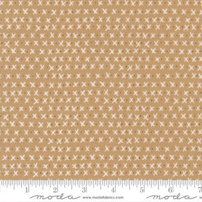 The image is a fabric with a repeating pattern of white crosses on a beige background.