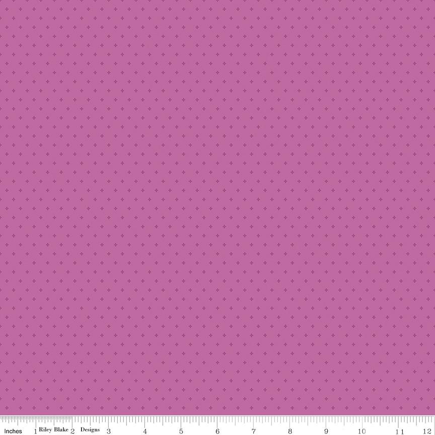 The image is a close-up of a fabric with a pink background and small white dots, resembling a polka dot pattern.
