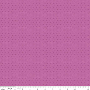 The image is a close-up of a fabric with a pink background and small white dots, resembling a polka dot pattern.