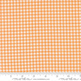 The image is a fabric with a repeating pattern of orange and white houndstooth shapes, creating a textured and visually interesting design.