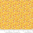 The image is a fabric with a yellow background and a pattern of small flowers in various colors, including red, white, and green.