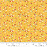 The image is a fabric with a yellow background and a pattern of small flowers in various colors, including red, white, and green.