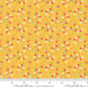 The image is a fabric with a yellow background and a pattern of small flowers in various colors, including red, white, and green.