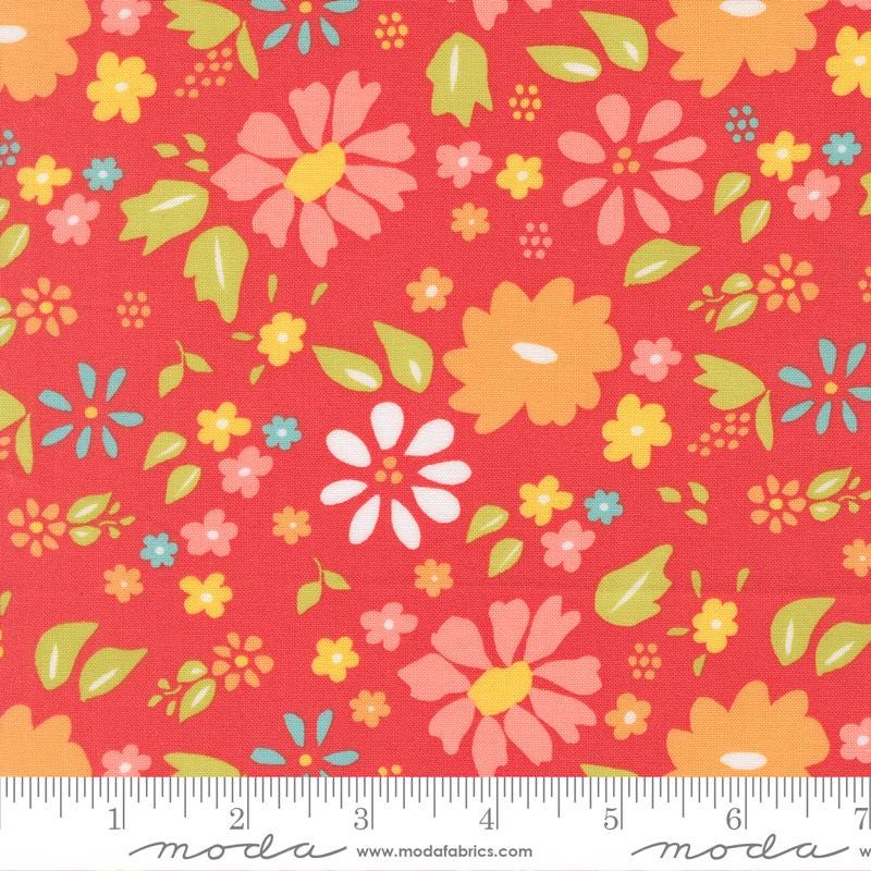 The image is a vibrant red fabric with a repeating pattern of colorful flowers and leaves. The flowers are depicted in various shades of pink, yellow, and orange, while the leaves are shown in shades of green and blue. The fabric appears to be a textile or fabric material, with a ruler visible in the bottom right corner for scale.
