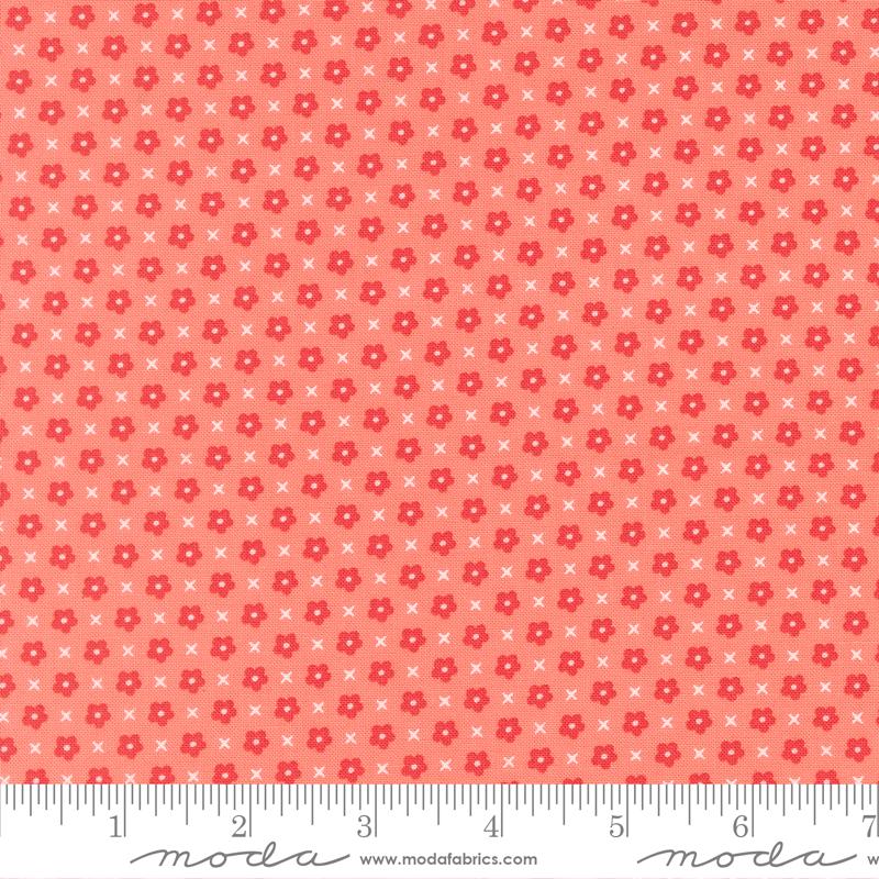 The image is a fabric with a repeating pattern of red flowers and white crosses. The pattern is composed of small dots and lines, creating a visually appealing and textured design.