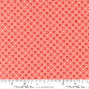 The image is a fabric with a repeating pattern of red flowers and white crosses. The pattern is composed of small dots and lines, creating a visually appealing and textured design.