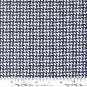 a close-up view of a fabric with a repeating pattern of white and navy blue houndstooth shapes.