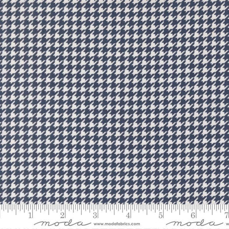 a close-up view of a fabric with a repeating pattern of white and navy blue houndstooth shapes.