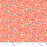 The image is a fabric with a floral pattern in shades of pink and orange. The pattern consists of small flowers and leaves scattered across the fabric, creating a vibrant and colorful design.