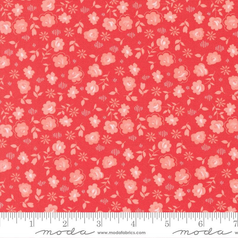 The image is a close-up of a fabric with a repeating pattern of pink flowers and leaves on a red background.