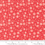 The image is a close-up of a fabric with a repeating pattern of pink flowers and leaves on a red background.