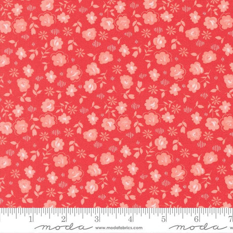 The image is a close-up of a fabric with a repeating pattern of pink flowers and leaves on a red background.