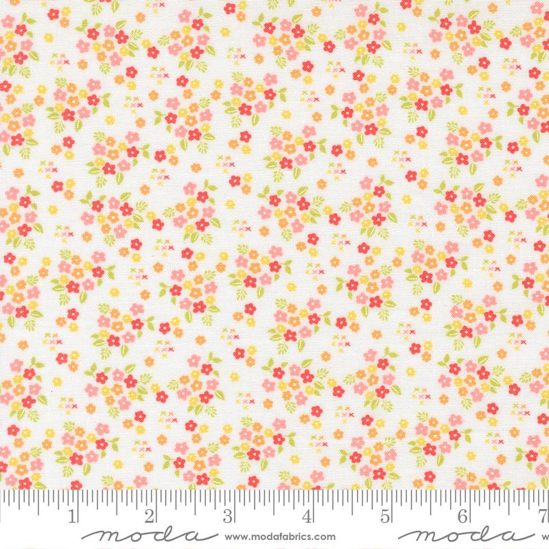 The image is a fabric with a floral pattern, featuring small red, yellow, and green flowers scattered across a white background.