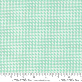 a fabric with a repeating pattern of green and white houndstooth shapes, creating a houndstooth pattern.