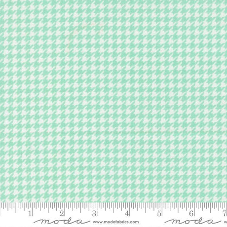 a fabric with a repeating pattern of green and white houndstooth shapes, creating a houndstooth pattern.