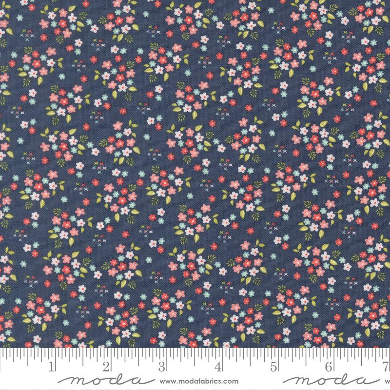 The image is a close-up of a fabric with a floral pattern, featuring small flowers in various colors and sizes against a dark blue background.
