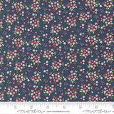 The image is a close-up of a fabric with a floral pattern, featuring small flowers in various colors and sizes against a dark blue background.