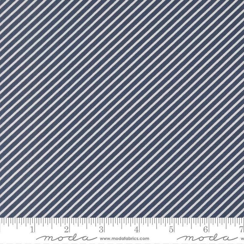 a close-up view of a fabric with diagonal white stripes arranged in a diagonal pattern. The fabric appears to be navy blue in color.