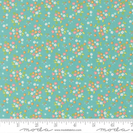 a fabric with a floral pattern in shades of green and pink. The pattern consists of small flowers and leaves scattered across the fabric, creating a vibrant and colorful design.