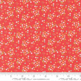 The image is a vibrant red fabric with a repeating pattern of small white and pink flowers and leaves. The fabric appears to be a fabric with a floral print, and it is displayed on a ruler for size reference.