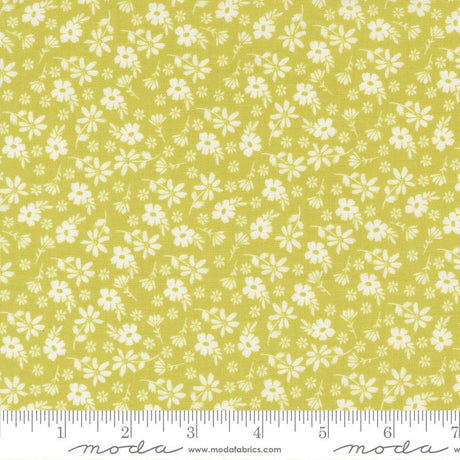a fabric with a repeating pattern of white flowers on a yellow background. The fabric appears to be a fabric with a floral print, and it is displayed on a ruler for size reference.