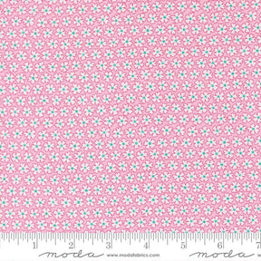 a close-up view of a fabric with a pink floral pattern. The fabric appears to be made of Moda cotton material, as indicated by the text in the image.
