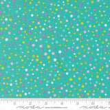 The image is a close-up of a fabric with a pattern of multicolored dots in various shades of green, yellow, and pink. The dots are scattered randomly across the fabric, creating a vibrant and lively visual effect.