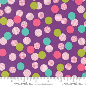 The image is a fabric with a pattern of multicolored polka dots in shades of purple, pink, green, and white. The pattern is spread across the fabric, creating a visually appealing and vibrant design.