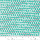 a fabric with a repeating pattern of white and pink flowers on a turquoise background. The fabric appears to be a textile or material with a floral design.
