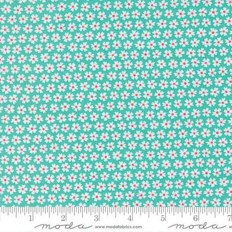 a fabric with a repeating pattern of white and pink flowers on a turquoise background. The fabric appears to be a textile or material with a floral design.