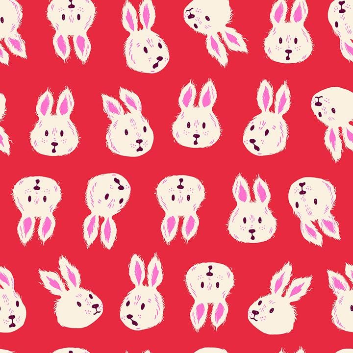 a repeating pattern of white rabbit faces on a red background.