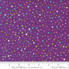 The image is a fabric with a purple background and multicolored polka dots scattered across it.