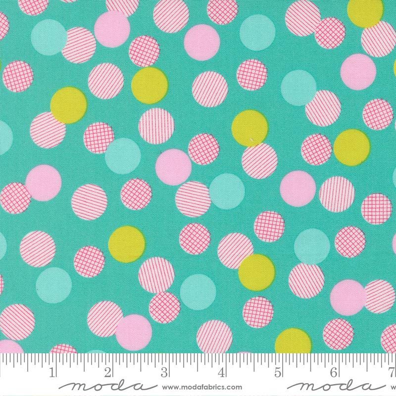 The image is a fabric with a pattern of multicolored polka dots in various shades of pink, yellow, and green. The pattern is scattered across the fabric, creating a vibrant and playful design.