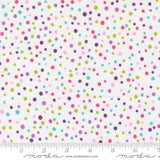 The image is a fabric with a pattern of multicolored polka dots in various shades of pink, green, blue, and purple. The fabric is displayed on a ruler for scale, indicating its size.