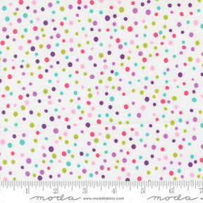 The image is a fabric with a pattern of multicolored polka dots in various shades of pink, green, blue, and purple. The fabric is displayed on a ruler for scale, indicating its size.