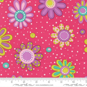 The image is a vibrant and colorful fabric with a repeating pattern of large, stylized flowers in shades of pink, purple, and yellow, along with polka dots and dots. The fabric appears to be a soft pink color, and the pattern is spread across the entire surface, creating a visually striking and lively design.