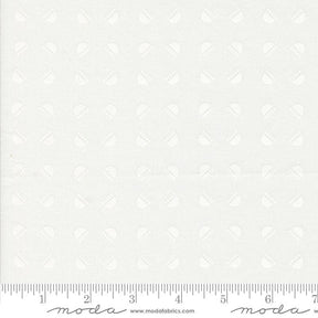 The image is a plain white fabric with a repeating pattern of circles or dots. There is a ruler at the bottom of the image for scale.