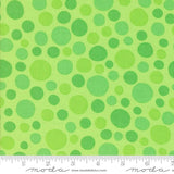 The image is a fabric with a green polka dot pattern.